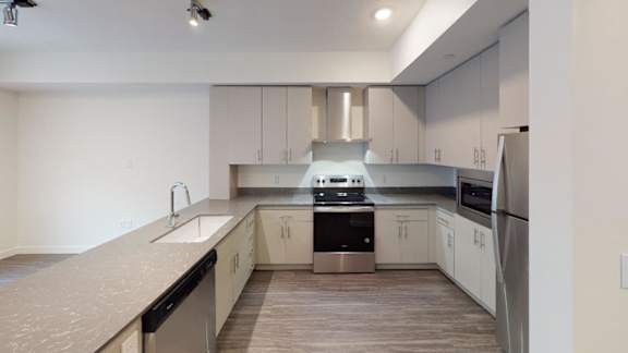 A modern kitchen with stainless steel appliances and white cabinets. at Paperbox Lofts Apartments, Salt Lake City  , 84101