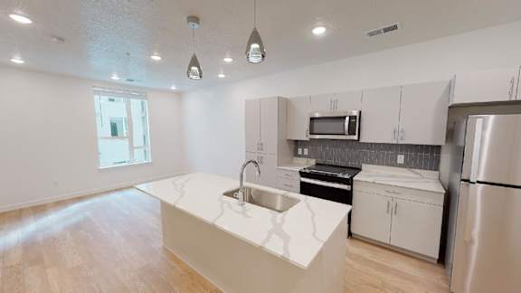 A kitchen with a white counter top and stainless steel appliances.