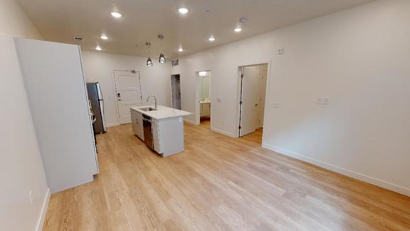 A room with a white fridge, a white table, and a white cabinet.