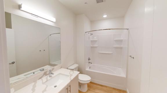 A white bathroom with a toilet, sink, and bathtub.
