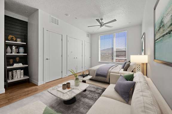 A living room with a couch, a coffee table, and a painting on the wall.