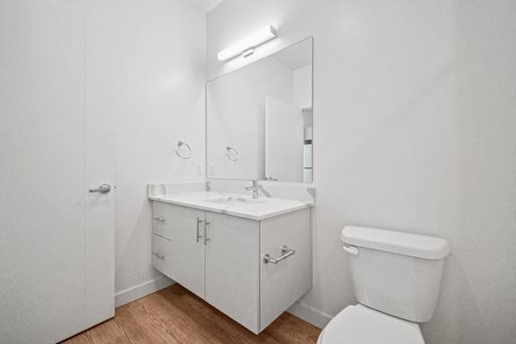 A white bathroom with a toilet, sink, and medicine cabinet.