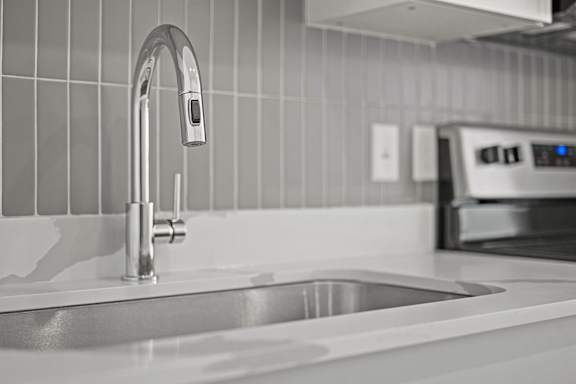 A modern kitchen sink with a chrome faucet.