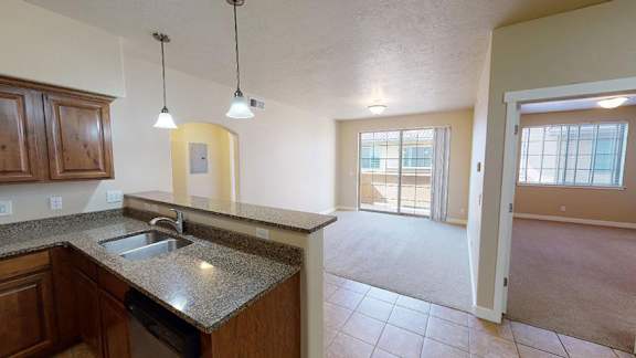 A kitchen with a granite countertop and wooden cabinets. at Siena Villas Apartments, Utah