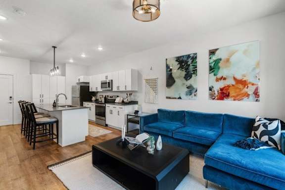 Open concept living room with blue sectional sofa at The Revival Apartments, Salt Lake City, UT