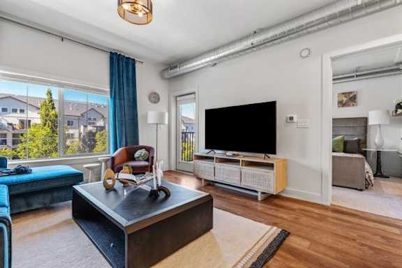 Living room with large tv and blue furnishings at The Revival Apartments, Salt Lake City, 84101