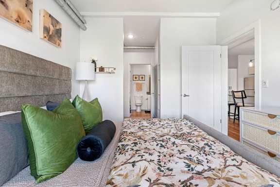 Bedroom with floral bedding and en suite bathroom at The Revival Apartments, Utah, 84101