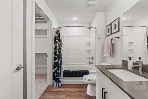 A bathroom with a toilet and bathtub with curtain. at The Revival, Utah