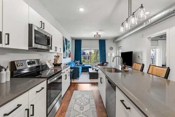 A modern kitchen with stainless steel appliances and a view of the backyard. at The Revival, Salt Lake City, UT 84101