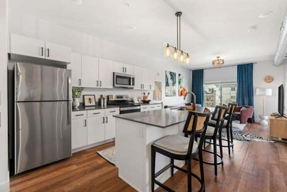 A modern kitchen with a large island and stainless steel appliances.