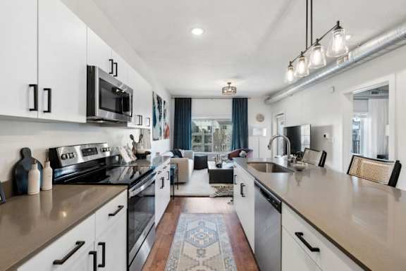 A modern kitchen with white cabinets and a large island.