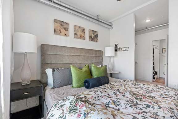 A bedroom with a floral bedspread and a headboard.