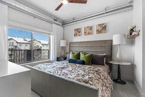A bedroom with a large bed and a ceiling fan.