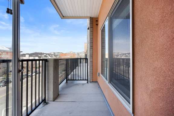 A balcony with a metal railing and a view of the city.