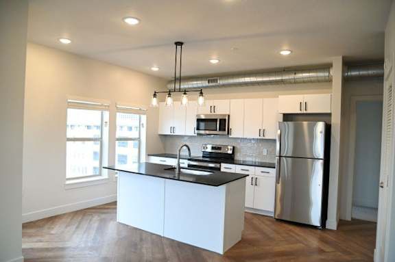 A modern kitchen with stainless steel appliances and white cabinetry.