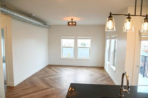A kitchen with a black countertop and wooden flooring.