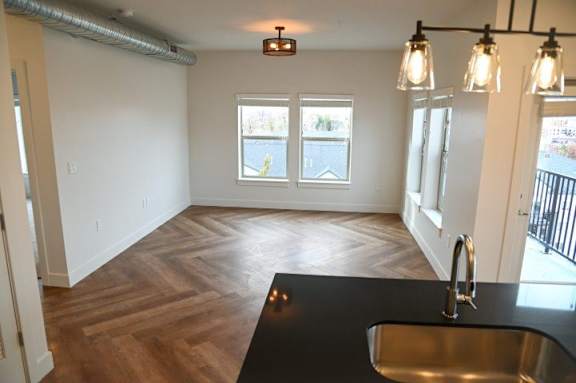 A kitchen with a black countertop and a stainless steel sink.
