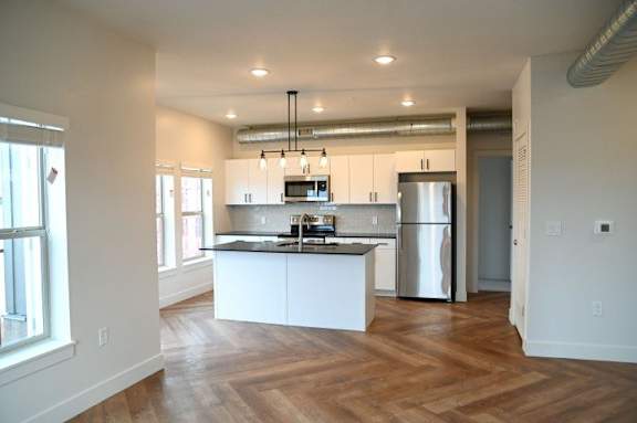 A kitchen with a refrigerator and a counter.