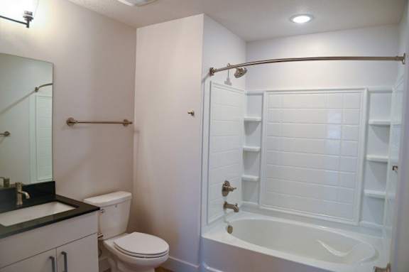 A white bathroom with a toilet, sink, and bathtub.