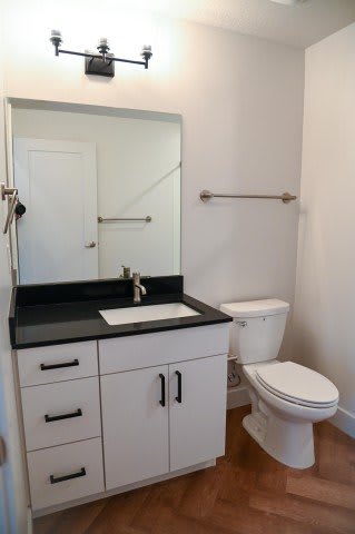 A white toilet sits next to a sink in a bathroom.