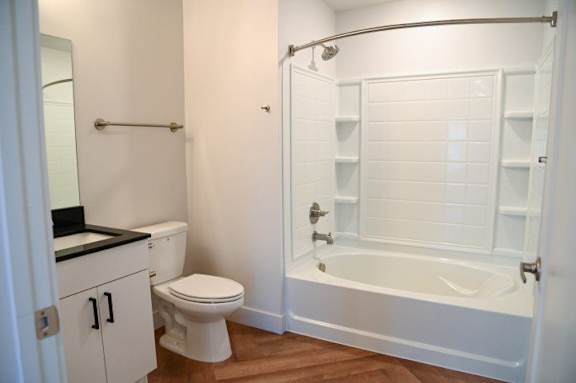 A white bathroom with a toilet, sink, and bathtub.