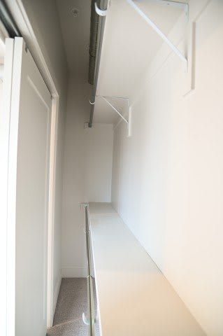 A long white hallway with a carpeted floor.