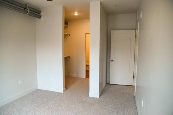 A room with a carpeted floor and a white door.
