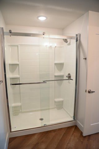 A white bathroom with a walk in shower.