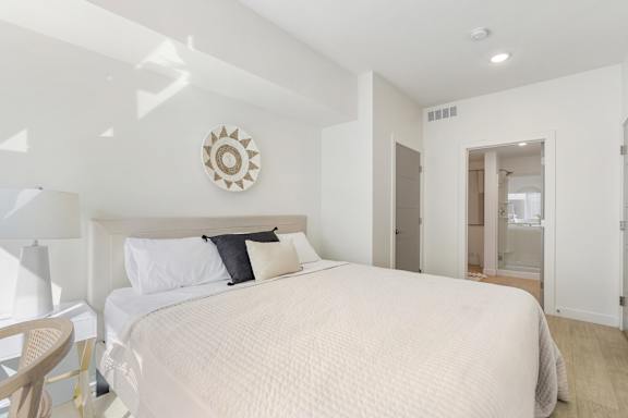 A bedroom with a large bed and a round decorative piece on the wall. at Paperbox Lofts Apartments, Salt Lake City  , UT, 84101