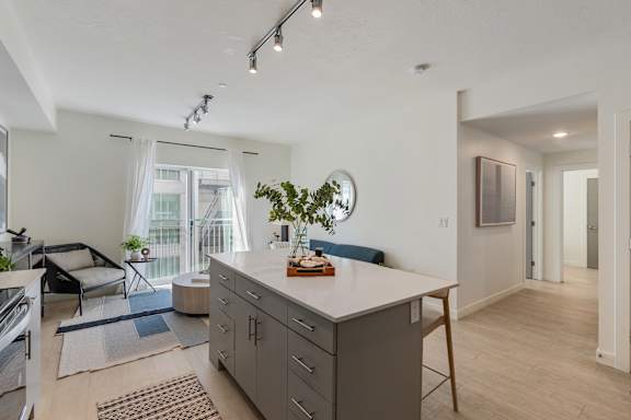 A modern kitchen with a large island and a dining area. at Paperbox Lofts Apartments, Utah