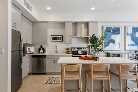 A modern kitchen with a refrigerator, stove, and sink. at Paperbox Lofts Apartments, Utah
