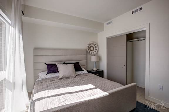 A bedroom with a large bed and a window with curtains. at Paperbox Lofts Apartments, Utah, 84101