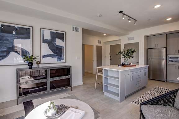 A modern kitchen with a refrigerator, microwave, and a dining table with chairs. at Paperbox Lofts Apartments, Utah