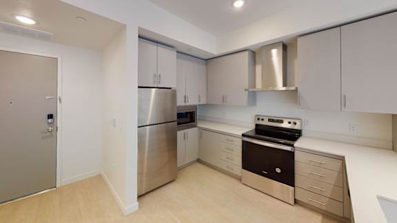 A modern kitchen with stainless steel appliances and white cabinets at Paperbox Lofts Apartments, Apartments, Salt Lake City  , UT