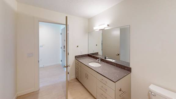 A bathroom with a sink, mirror, and toilet. at Paperbox Lofts Apartments, Utah