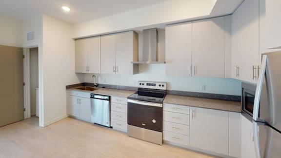 A kitchen with white cabinets and appliances. at Paperbox Lofts Apartments, Salt Lake City  , Utah