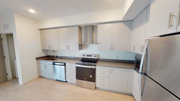 A kitchen with white cabinets and stainless steel appliances. at Paperbox Lofts Apartments, Salt Lake City