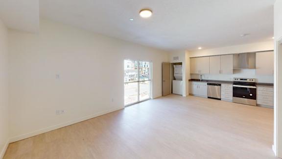 A spacious, empty room with wooden flooring and white walls. at Paperbox Lofts Apartments, Salt Lake City  , UT, 84101