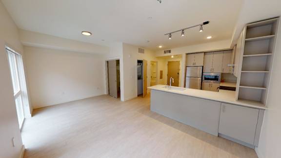 A large, empty room with a bar area and a window. at Paperbox Lofts Apartments, Utah