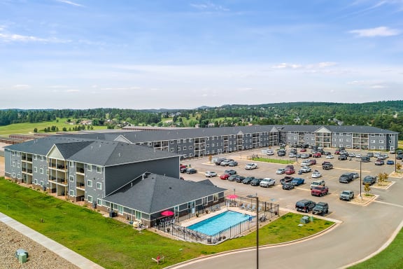 a large apartment complex with a swimming pool and parking lot