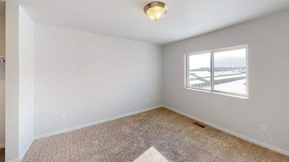 A room with a carpeted floor and a window overlooking a beach at Red Rock Apartments, Rapid City, SD, 57702