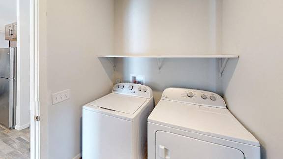 Two white front loading washing machines in a laundry room at Red Rock Apartments, South Dakota 57702