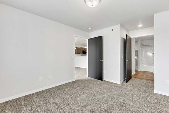 a bedroom with grey carpet and white walls at Red Rock Apartments, Rapid City, South Dakota