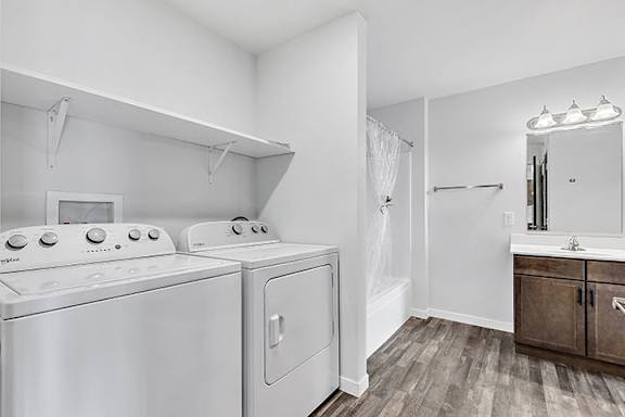 a bathroom with a washer and dryer and a sink at Red Rock Apartments, Rapid City