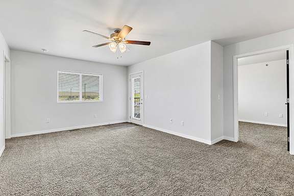 a bedroom with a ceiling fan and carpet at Red Rock Apartments, Rapid City, 57702