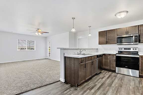 a kitchen and living room with wood floors and white walls at Red Rock Apartments, Rapid City, SD