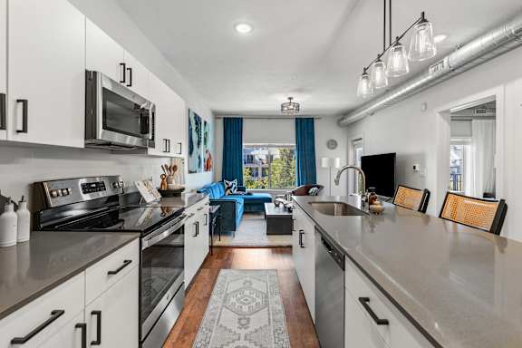 A modern kitchen with stainless steel appliances and a view of the backyard. at The Revival, Salt Lake City, UT 84101
