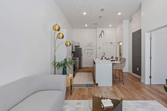 A modern living room with a grey sofa and a glass coffee table.