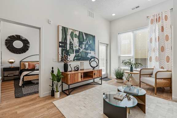 A modern living room with a large painting on the wall and a wreath on the door.