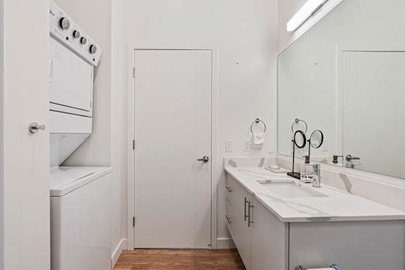 A white bathroom with a white oven and a white door.